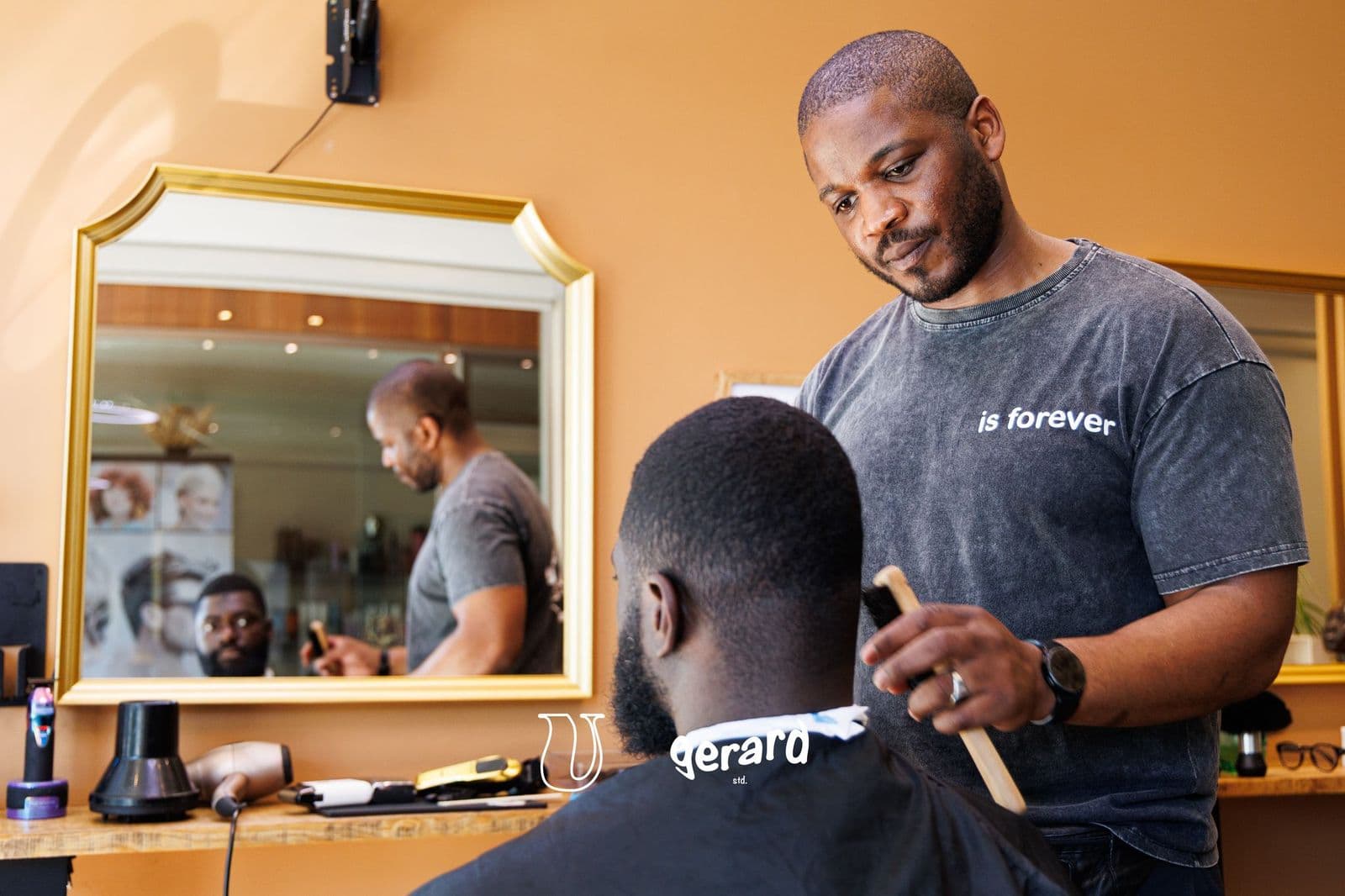 Barber brushing a client's neck after a cut at Ubuntu Barbershop in Aalter